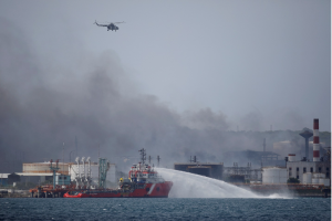 Một máy bay trực thăng bay qua khu vực có các thùng chứa nhiên liệu phát nổ gần cảng siêu tàu chở dầu ở Matanzas, Cuba. (nguồn: Reuters)